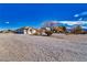 Wide view of the stucco home with extensive gravel landscaping and large desert trees at 660 Indian Rd, Pahrump, NV 89048