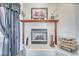 Close-up of a tiled fireplace with a wood mantel, decorative items, and stacked firewood at 660 Indian Rd, Pahrump, NV 89048