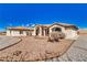 Desert-landscaped front exterior featuring a single-story stucco home with arched entryway and red front door at 660 Indian Rd, Pahrump, NV 89048