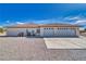 Three-car garage with concrete driveway, neutral stucco, and desert landscape at 660 Indian Rd, Pahrump, NV 89048