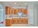 Functional kitchen with wood cabinetry, tile countertops, and a corner sink at 660 Indian Rd, Pahrump, NV 89048