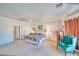 Spacious main bedroom with a ceiling fan, comfortable bed, and cozy sitting area at 660 Indian Rd, Pahrump, NV 89048