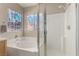 Bright bathroom featuring a large soaking tub, glass enclosed shower and unique windows at 682 Baffin Island Rd, Henderson, NV 89011