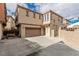 Tan two-story home featuring a two-car garage, tile roof, and gated front porch at 682 Baffin Island Rd, Henderson, NV 89011