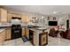 Open-concept kitchen with breakfast bar, black appliances, and tiled flooring at 682 Baffin Island Rd, Henderson, NV 89011
