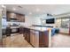 Open kitchen with stainless steel appliances, dark wood cabinets, and a spacious island perfect for entertaining at 795 Pickled Pepper Pl, Henderson, NV 89011