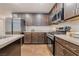 Beautiful kitchen featuring stainless steel appliances, light countertops, dark wood cabinets, and tile flooring at 795 Pickled Pepper Pl, Henderson, NV 89011