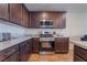 Kitchen features stainless steel appliances, dark wood cabinets, and light countertops at 795 Pickled Pepper Pl, Henderson, NV 89011