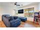 Comfortable living room featuring a blue sectional, mounted TV, and a vintage arcade game at 795 Pickled Pepper Pl, Henderson, NV 89011