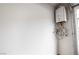 A tankless water heater installed near the garage door on the white wall at 795 Pickled Pepper Pl, Henderson, NV 89011