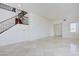 Spacious living room with tile floors and staircase with wood and iron railings at 9003 Greek Palace Ave, Las Vegas, NV 89178