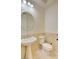 Classic powder room with pedestal sink, oval mirror, and elegant beige tiling at 9003 Greek Palace Ave, Las Vegas, NV 89178