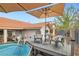 Charming backyard pool area with a deck, seating, and umbrellas for relaxed outdoor living at 905 White Thunder St, Henderson, NV 89002