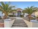 Inviting entryway with tiled steps, mature landscaping, and an arched entrance highlighting this lovely home at 905 White Thunder St, Henderson, NV 89002