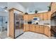Well-lit kitchen showcases stainless steel fridge, lots of wood cabinets and modern appliances at 905 White Thunder St, Henderson, NV 89002