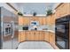 Kitchen with stainless steel refrigerator, oven, microwave and ample light wood cabinetry at 905 White Thunder St, Henderson, NV 89002