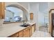 Bright kitchen featuring white countertops, wood cabinets and modern sink with archway to living room at 905 White Thunder St, Henderson, NV 89002