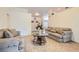 Cozy living room showcasing comfortable sofas, a glass coffee table, and neutral tile flooring at 905 White Thunder St, Henderson, NV 89002