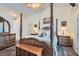 A luxurious main bedroom with a four-poster bed and ample natural light, providing a tranquil retreat at 905 White Thunder St, Henderson, NV 89002