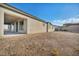 Spacious backyard showcasing a modern, neutral-toned home and clear blue skies at 9570 Verde Way, Las Vegas, NV 89149