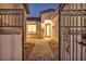 Charming courtyard entrance with a decorative wrought iron gate and brick pathway, leading to a stylish front door at 9570 Verde Way, Las Vegas, NV 89149