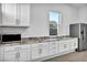 Bright kitchen featuring granite countertops, white cabinets, stainless appliances, and a window at 9570 Verde Way, Las Vegas, NV 89149