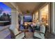 Inviting covered back porch with a fire pit, comfortable seating, and an outdoor kitchen area, perfect for entertaining at 9668 Doraville Ave, Las Vegas, NV 89149