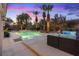 Twilight view of an inviting pool and spa area surrounded by lush landscaping, creating a serene backyard oasis at 9668 Doraville Ave, Las Vegas, NV 89149