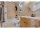 Well-lit bathroom featuring a vanity with wood cabinets, tan countertops and tile, and a shower-tub combo at 9668 Doraville Ave, Las Vegas, NV 89149