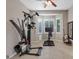 Bright exercise room featuring tile floors, workout equipment, and natural light from the bay window at 9668 Doraville Ave, Las Vegas, NV 89149