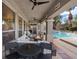 Inviting covered patio with a fire pit, ample seating, and view of a sparkling pool for outdoor relaxation at 9668 Doraville Ave, Las Vegas, NV 89149