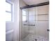 Walk-in shower with glass doors, rain shower head, and stone tile at 9817 Kernville Dr, Las Vegas, NV 89134