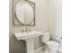 Chic powder room features a pedestal sink, round mirror, and modern fixtures at 9938 Regency Canyon Way, Las Vegas, NV 89148