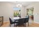 Bright dining room featuring modern light fixture, stylish table, and access to outdoor space at 9938 Regency Canyon Way, Las Vegas, NV 89148