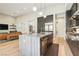 Open floor plan featuring a modern kitchen island with seating, stainless steel appliances, and seamless transition to living space at 9938 Regency Canyon Way, Las Vegas, NV 89148