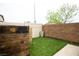 Cozy backyard featuring artificial grass, wood accent wall, and neutral colored brick for privacy at 10323 Hardy Falls St, Las Vegas, NV 89141