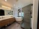 Modern bathroom featuring a large soaking tub, glass enclosed shower, and dual sink vanity at 10323 Hardy Falls St, Las Vegas, NV 89141