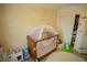 Bedroom with palm wallpaper features a cozy crib with canopy, play kitchen and closet at 10323 Hardy Falls St, Las Vegas, NV 89141