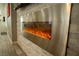 Close up of a modern fireplace with decorative stone accent wall and stainless steel accents in the living room at 10323 Hardy Falls St, Las Vegas, NV 89141
