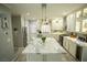 Bright kitchen with white cabinets, large island, stainless steel appliances and gray wood-look tile floors at 10323 Hardy Falls St, Las Vegas, NV 89141