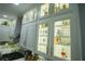 Bright kitchen featuring white cabinets with glass doors and interior lighting, showcasing barware and collectibles at 10323 Hardy Falls St, Las Vegas, NV 89141