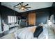 Dark bedroom with modern furniture, a canopy bed and a sliding barn door to ensuite bathroom at 10323 Hardy Falls St, Las Vegas, NV 89141