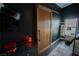 View of a modern bedroom featuring a sliding barn door, dark walls, and industrial lighting at 10323 Hardy Falls St, Las Vegas, NV 89141