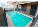 Backyard pool with safety fence, covered patio, and mature landscaping at 10323 Hardy Falls St, Las Vegas, NV 89141