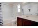 Bright bathroom features white fixtures, a shower and bath combination, and a large vanity at 10478 Beallsville St, Las Vegas, NV 89141