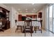 Well-lit dining area with a wooden table, view to the kitchen and sliding glass doors at 10478 Beallsville St, Las Vegas, NV 89141
