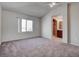 Bright main bedroom featuring neutral carpet, ample natural light, and an en-suite bathroom at 10478 Beallsville St, Las Vegas, NV 89141