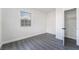 Clean bedroom with gray laminate floors, closet, window with security bars, and white paint at 116 W Victory Rd, Henderson, NV 89015