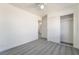 Bright bedroom featuring modern ceiling fan, closet, and stylish gray wood-look flooring at 116 W Victory Rd, Henderson, NV 89015