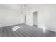 Bright bedroom featuring modern ceiling fan, closet, and stylish gray wood-look flooring at 116 W Victory Rd, Henderson, NV 89015